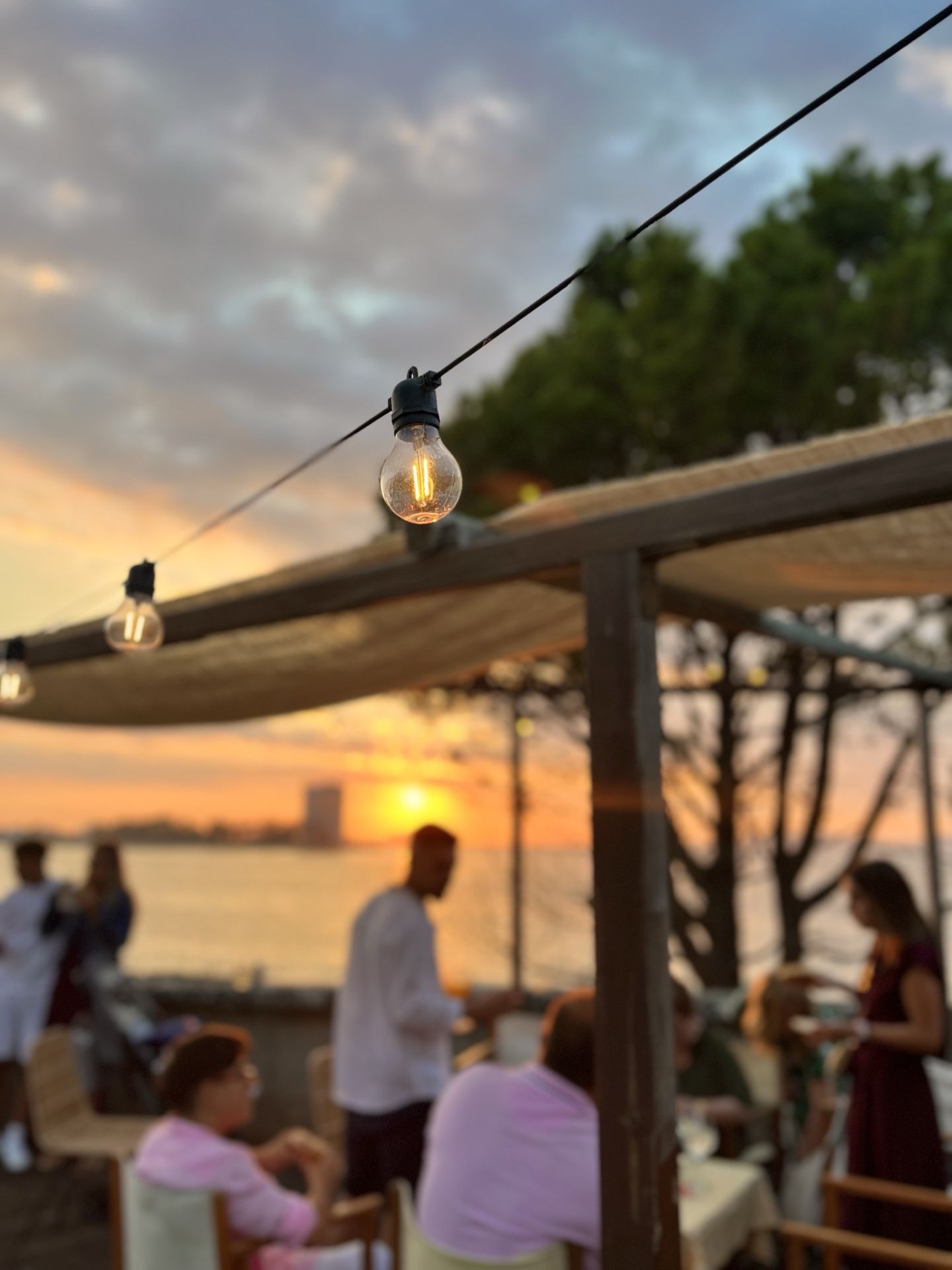Atardecer sobre la ría de Vigo desde la terraza de Finca Fontaíña, con guirnaldas de luces