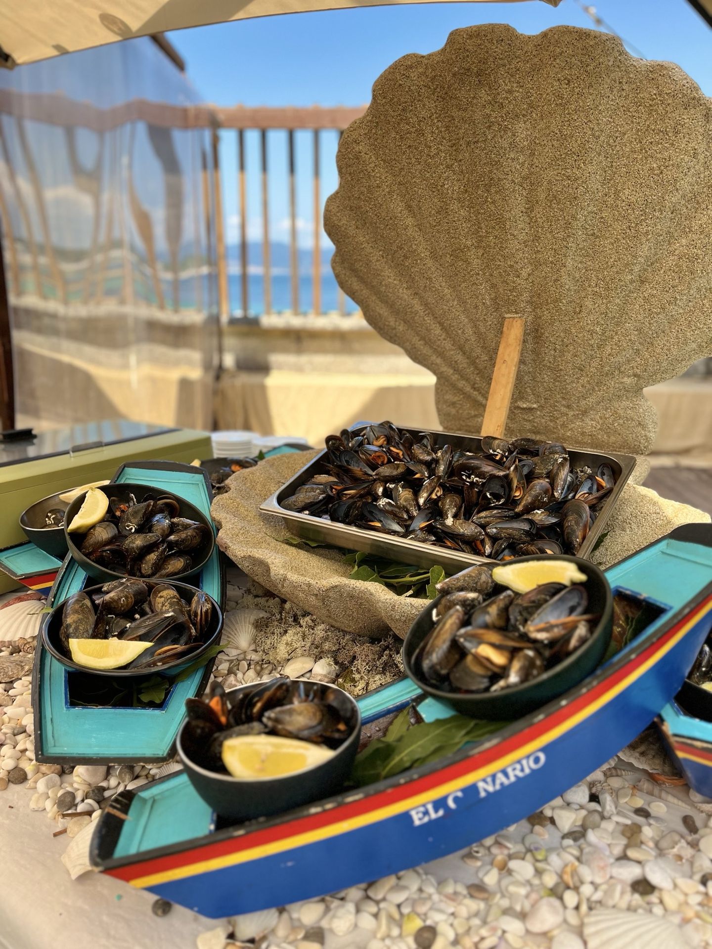 Mejillones servidos en un barco de madera con el rótulo de El Canario, estación de marisco en Finca Fontaíña