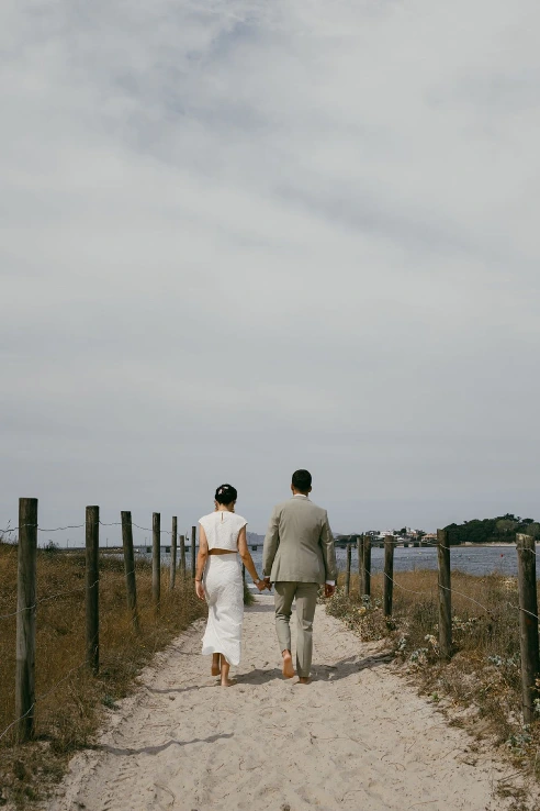 Pareja de novios paseando por el camino de arena hacia la playa de Fontaíña, en Vigo