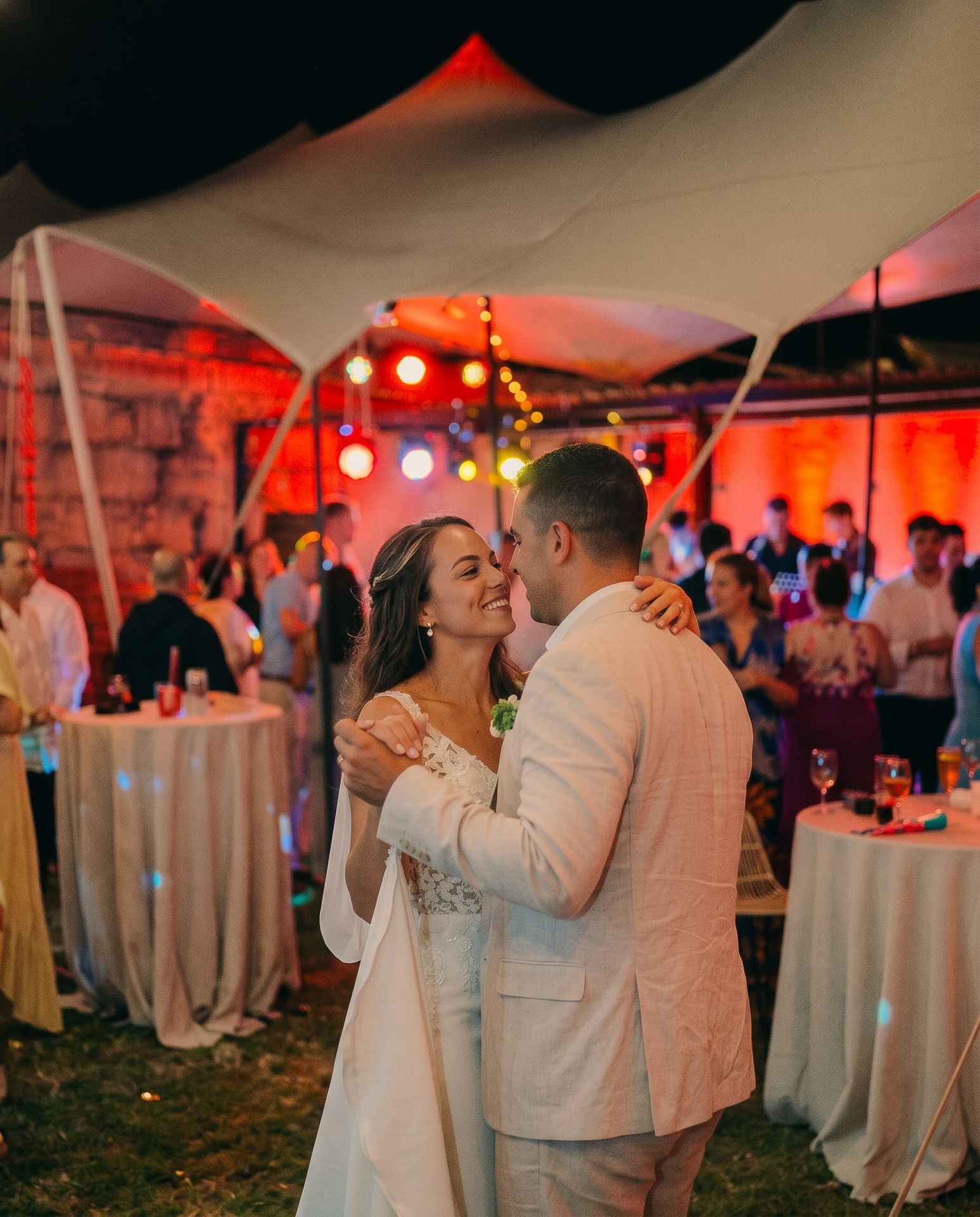 Novios bailando de noche bajo la carpa